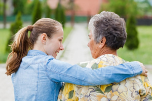 Bildinhalt: eine junge Frau umarmt eine ältere Frau
